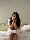 Depressed woman sitting on bed — Stock Photo