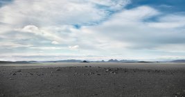 Серый бесплодный пейзаж под облачным небом — стоковое фото
