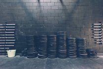 Stacked rows of barbell weights in black gym — Stock Photo