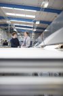 Manager and factory worker discussing work in roller blind factory — Stock Photo