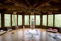 Woman in yoga position in wooden house — Stock Photo