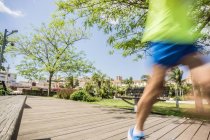 Blurred motion of runner running on park boardwalk — Stock Photo