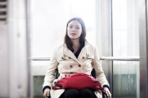 Портрет молодой женщины с инвалидной коляской в лифте — стоковое фото