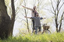 Young couple with bicycle in rural woodland — Stock Photo