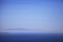 Vista sul mare e sulla nebbia dell'isola di Andros dall'isola di Tinos, Grecia — Foto stock