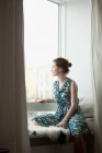 Woman looking out of the window — Stock Photo