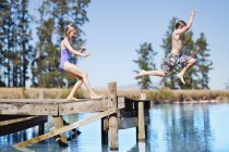 Crianças saltando no lago a partir de molhe — Fotografia de Stock