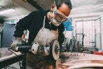 Metallbauer poliert Kupfer in Schmiedewerkstatt — Stockfoto