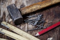 Nahaufnahme von Bleistift, Nägeln, Hammer, Zick-Zack-Lineal auf Holzoberfläche — Stockfoto