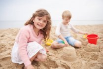 Bambini costruzione castello di sabbia sulla spiaggia — Foto stock