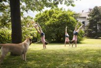 Composito multiplo di giovane donna che fa handstanding in giardino — Foto stock