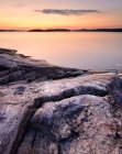 Long expposure shot of rocky lakeside in sunset light — Stock Photo