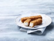 Dedos de pescado empanados porción en el plato - foto de stock