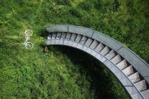 Bicycle in grass under spiral staircase — Stock Photo