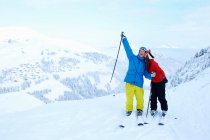 Skiers celebrating on snowy mountaintop — Stock Photo