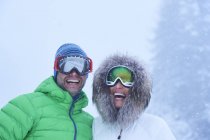 Portrait of happy mature couple in falling snow, Gstaad, Switzerland — Stock Photo