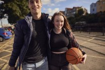 Two friends walking outdoors, young woman holding basketball, Bristol, UK — Stock Photo