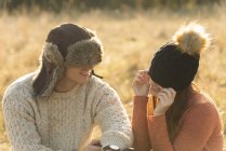 Young couple wearing warm hats in field — Stock Photo