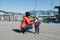 Madre che mette il casco protettivo sul figlio — Foto stock