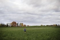 Young girl running in open field, Lakefield, Ontario, Canada — Stock Photo