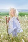 Дівчина Тоддлер стоїть у високій траві — стокове фото