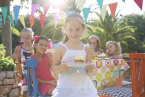 Девушки на дне рождения держат тарелку с кексом — стоковое фото