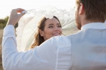 Casal recém-casado de pé ao ar livre — Fotografia de Stock
