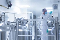 Travailleur exploitant un équipement de production pharmaceutique dans une usine pharmaceutique — Photo de stock