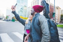Casal tirando selfie com smartphone na rua — Fotografia de Stock