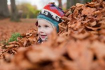 Chica en hojas de otoño - foto de stock