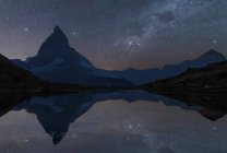 Cervin sous un ciel étoilé réfléchissant dans l'eau, Zermatt, Suisse — Photo de stock