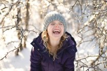 Портрет юной девушки, смеющейся в снежном пейзаже — стоковое фото