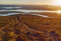 Man Trail läuft bei Sonnenuntergang auf Klippen, keimiotunturi, Lappland, Finnland — Stockfoto