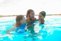 Man in swimming pool with daughter and son, Buonconvento, Tuscany, Italy — Stock Photo