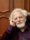 Smiling older man sitting in armchair — Stock Photo