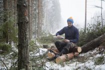 Logger taking break on logs, Tammela, Forssa, Finlandia - foto de stock