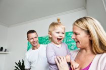 Mother and father with toddler daughter, smiling — Stock Photo