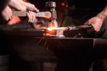 Farriers forging horseshoe on anvil, cropped image — Stock Photo