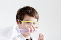 Student gießt Flüssigkeit in Reagenzgläser — Stockfoto