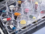 Ricerca farmaceutica, primo piano della varietà di farmaci medici in un vassoio multi bene per i test di laboratorio — Foto stock