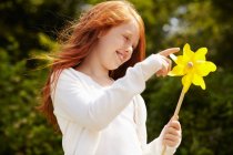 Menina brincando com pinwheel ao ar livre — Fotografia de Stock