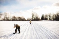 Girl picking up mitten on snow-covered path, Lakefield, Ontario, Canada — Stock Photo