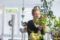 Blumenhändlerin wählt Blumen im Geschäft aus — Stockfoto