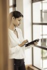 Giovane donna d'affari che utilizza tablet digitale in ufficio — Foto stock
