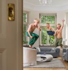 Хлопці у вітальні стрибають в повітрі — стокове фото