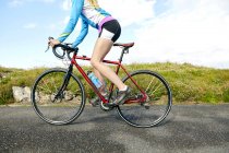 Велосипедист едет по проселочной дороге в солнечный день — стоковое фото