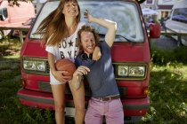 Giovane coppia che si diverte all'aperto, ridendo, giovane donna che tiene il basket — Foto stock