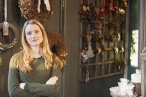 Портрет молодої жінки, що стоїть у магазині, складені руки — стокове фото
