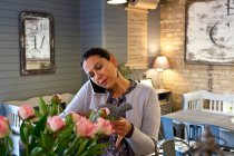 Reife Kundin liest Speisekarte, während sie im Café mit dem Smartphone spricht — Stockfoto