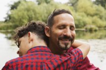 Portrait of father and son, outdoors, hugging — Stock Photo